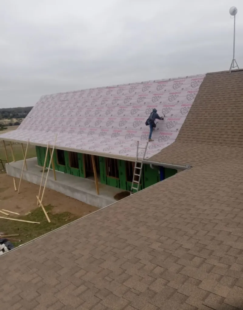Worker preparing underlayment for a metal roof installation in St. Simons